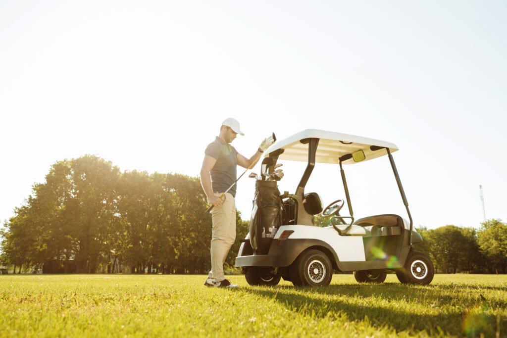 golfer taking clubs from a bag in a golf cart